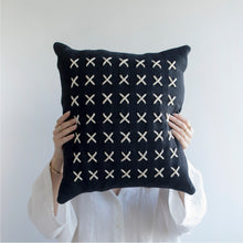 Load image into Gallery viewer,  Add a little bit of style and personality to your home with the X cushion. By playing with the negative spaces to create a unique feeling, the X cushion offers timeless aesthetic with a bold repetitive pattern.  Disclaimer: Every cushion is individually knitted and sewn by hand to ensure the highest level of comfort and long-lasting quality, which means you may find slight variations in design and size.  Cushion filling included. 42 x 42 cm 100% polyester