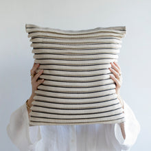 Load image into Gallery viewer, Our striped cushion is not like any other striped cushion. Thanks to special knitting techniques, three-dimensional fabric fold stripes are created.  Disclaimer: Every cushion is individually knitted and sewn by hand to ensure the highest level of comfort and long-lasting quality, which means you may find slight variations in design and size.  Cushion filling included. 43 x 43 cm 100% polyester
