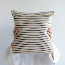 Load image into Gallery viewer, Our striped cushion is not like any other striped cushion. Thanks to special knitting techniques, three-dimensional fabric fold stripes are created.  Disclaimer: Every cushion is individually knitted and sewn by hand to ensure the highest level of comfort and long-lasting quality, which means you may find slight variations in design and size.  Cushion filling included. 43 x 43 cm 100% polyester