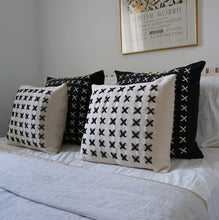 Load image into Gallery viewer, Add a little bit of style and personality to your home with the X cushion. By playing with the negative spaces to create a unique feeling, the X cushion offers timeless aesthetic with a bold repetitive pattern.  Disclaimer: Every cushion is individually knitted and sewn by hand to ensure the highest level of comfort and long-lasting quality, which means you may find slight variations in design and size.  Cushion filling included.  42 x 42 cm 100% polyester