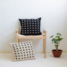 Load image into Gallery viewer, Add a little bit of style and personality to your home with the X cushion. By playing with the negative spaces to create a unique feeling, the X cushion offers timeless aesthetic with a bold repetitive pattern.  Disclaimer: Every cushion is individually knitted and sewn by hand to ensure the highest level of comfort and long-lasting quality, which means you may find slight variations in design and size.  Cushion filling included. 42 x 42 cm 100% polyester
