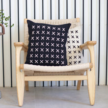 Load image into Gallery viewer, Add a little bit of style and personality to your home with the X cushion. By playing with the negative spaces to create a unique feeling, the X cushion offers timeless aesthetic with a bold repetitive pattern.  Disclaimer: Every cushion is individually knitted and sewn by hand to ensure the highest level of comfort and long-lasting quality, which means you may find slight variations in design and size.  Cushion filling included. 42 x 42 cm 100% polyester