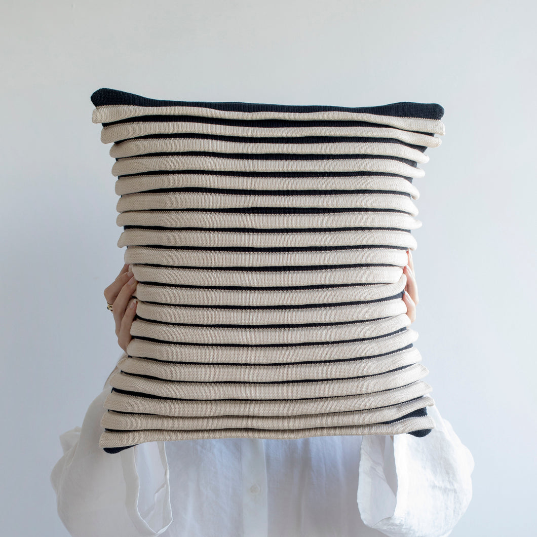 Our striped cushion is not like any other striped cushion. Thanks to special knitting techniques, three-dimensional fabric fold stripes are created.  Disclaimer: Every cushion is individually knitted and sewn by hand to ensure the highest level of comfort and long-lasting quality, which means you may find slight variations in design and size.  Cushion filling included. 43 x 43 cm 100% polyester