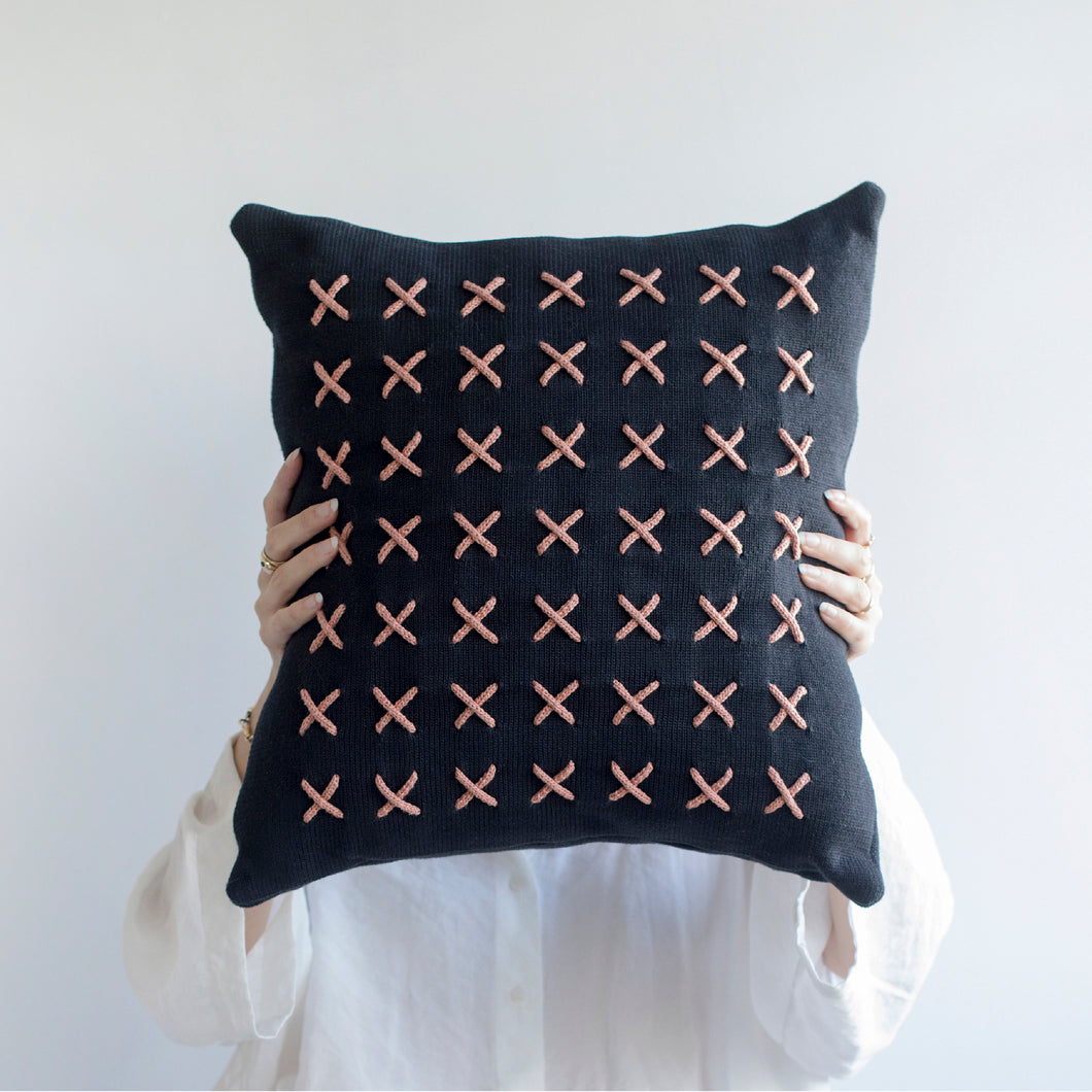 Add a little bit of style and personality to your home with the X cushion. By playing with the negative spaces to create a unique feeling, the X cushion offers timeless aesthetic with a bold repetitive pattern.  Disclaimer: Every cushion is individually knitted and sewn by hand to ensure the highest level of comfort and long-lasting quality, which means you may find slight variations in design and size.  Cushion filling included.  42 x 42 cm 100% polyester