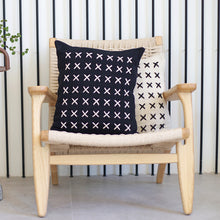 Load image into Gallery viewer, Add a little bit of style and personality to your home with the X cushion. By playing with the negative spaces to create a unique feeling, the X cushion offers timeless aesthetic with a bold repetitive pattern.  Disclaimer: Every cushion is individually knitted and sewn by hand to ensure the highest level of comfort and long-lasting quality, which means you may find slight variations in design and size.  Cushion filling included. 42 x 42 cm 100% polyester
